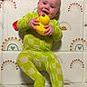 baby, checkered_pattern, child, childhood, colorful_background, cozy, cute, face, green_onesie, happy, indoor, infant, person, play_mat, playful, rubber_duck, sitting, smiling, toddler, toy