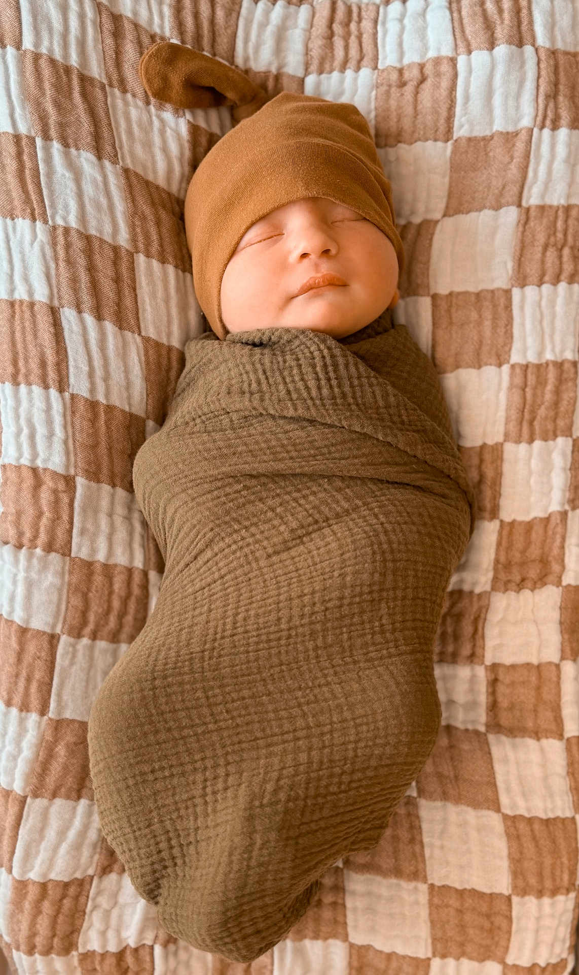 Luca joined the competition — help win amazing prizes! baby, sleeping, swaddle, hat, blanket, cozy, infant, cute, resting, child, soft, brown, checkered, fabric, newborn, portrait, peaceful, indoors, comfort, wrapped