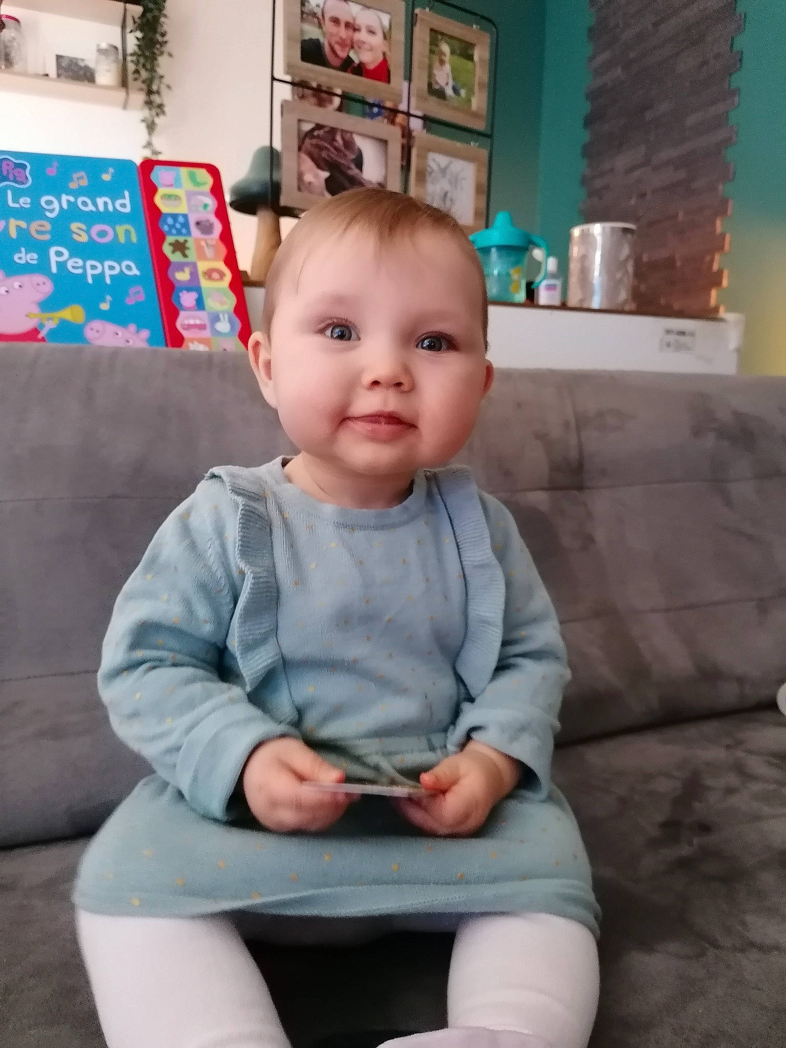 Elaïa a rejoint le concours — aidez-le/la à gagner de superbes lots ! baby, baby_toddler_clothing, cheek, child, comfort, couch, electric_blue, hairstyle, human_leg, joy, knee, lap, leg, living_room, person, picture_frame, sitting, sleeve, studio_couch, t_shirt