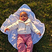 Luna a rejoint le concours — aidez-le/la à gagner de superbes lots ! baby, child, grass, blanket, smile, happy, outdoor, clothing, jacket, pants, socks, person, infant, portrait, nature, sunlight, cute, young_child, lying_down, warm_light