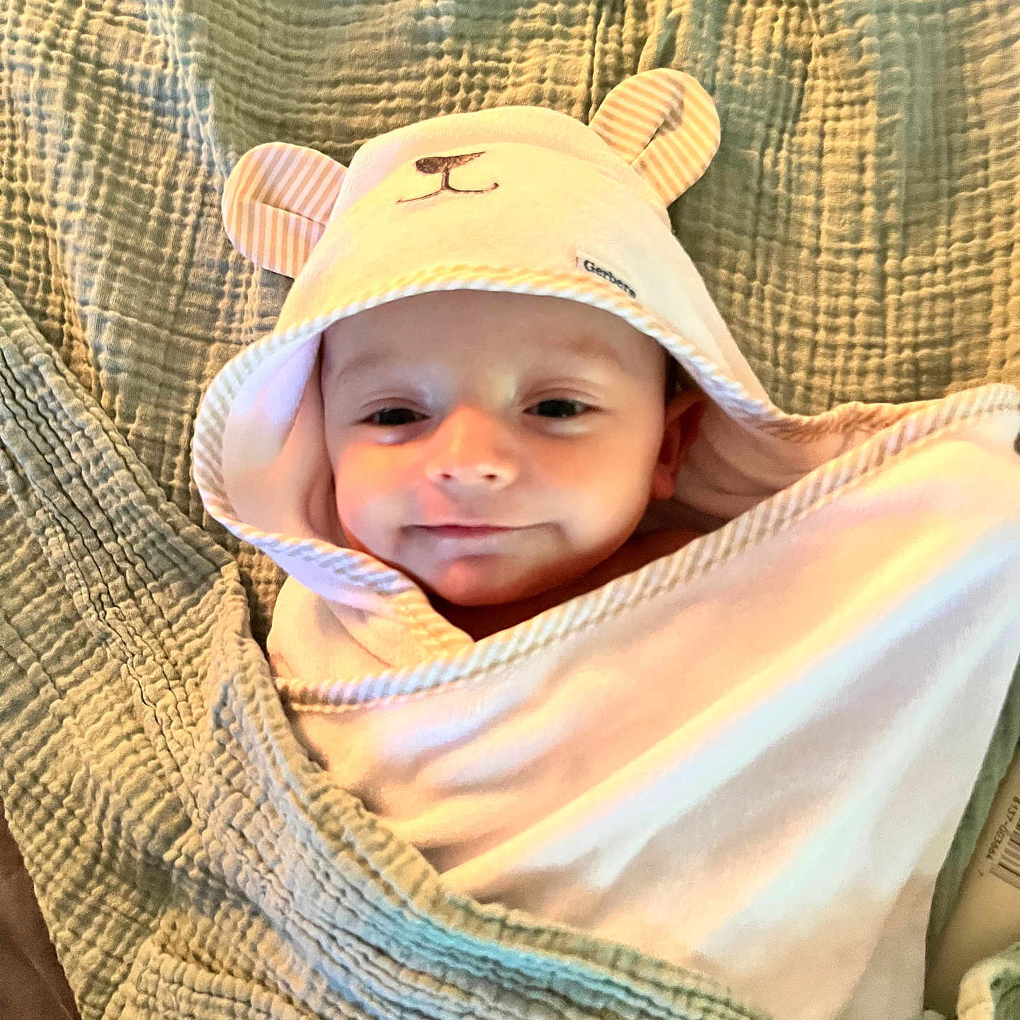 Easton Jo is registered to the contest to win money with this photo: adorable, baby, bear_ears, blanket, child, closeup, comfort, cozy, cute, face, hood, indoors, infant, lying_down, person, sleepy, smile, soft_texture, towel, wrapped