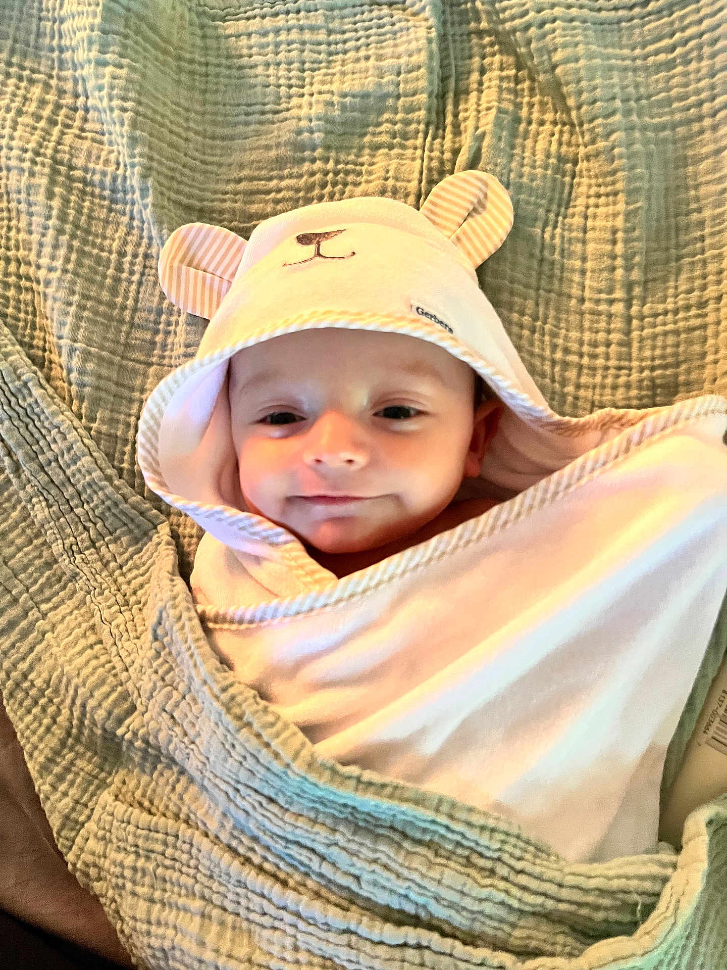 Easton Jo is registered to the contest to win money with this photo: adorable, baby, bear_ears, blanket, child, closeup, comfort, cozy, cute, face, hood, indoors, infant, lying_down, person, sleepy, smile, soft_texture, towel, wrapped