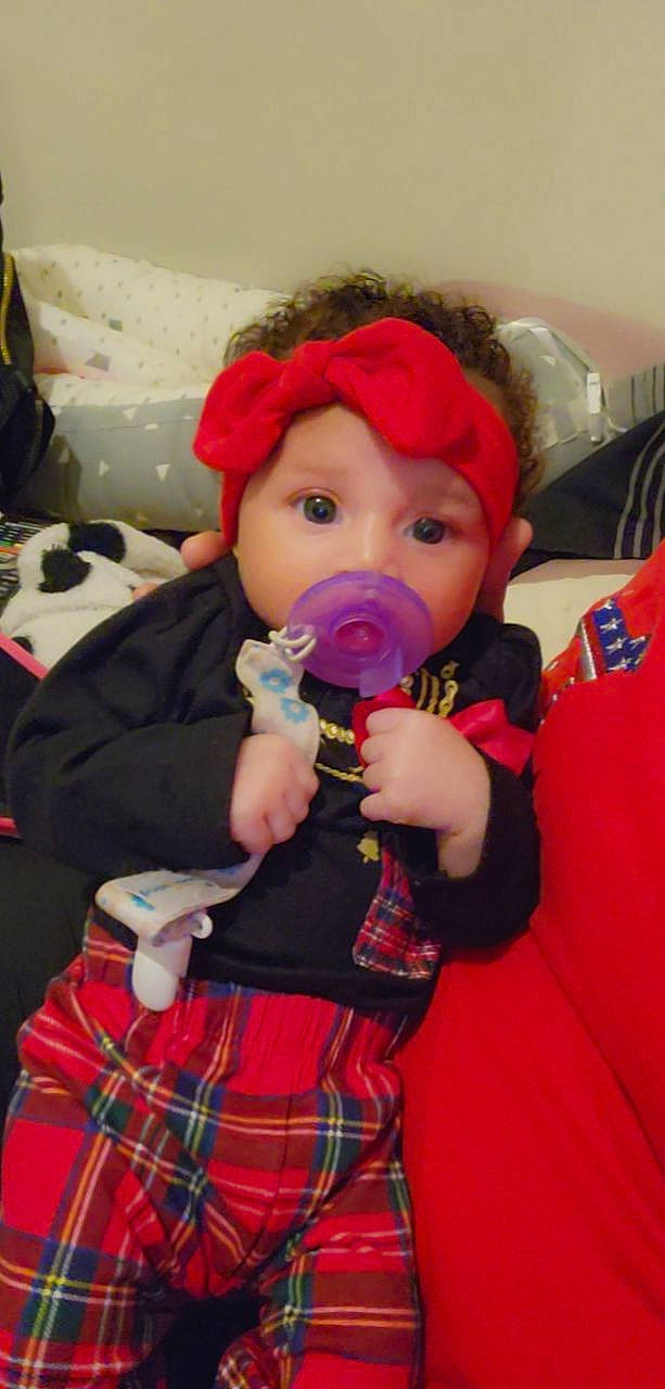 Leila is registered to the contest to win money with this photo: baby, baby_products, baby_toddler_clothing, cheek, child, costume, event, fun, hat, headwear, party, party_supply, pattern, person, plaid, red, room, stuffed_toy, tartan, textile