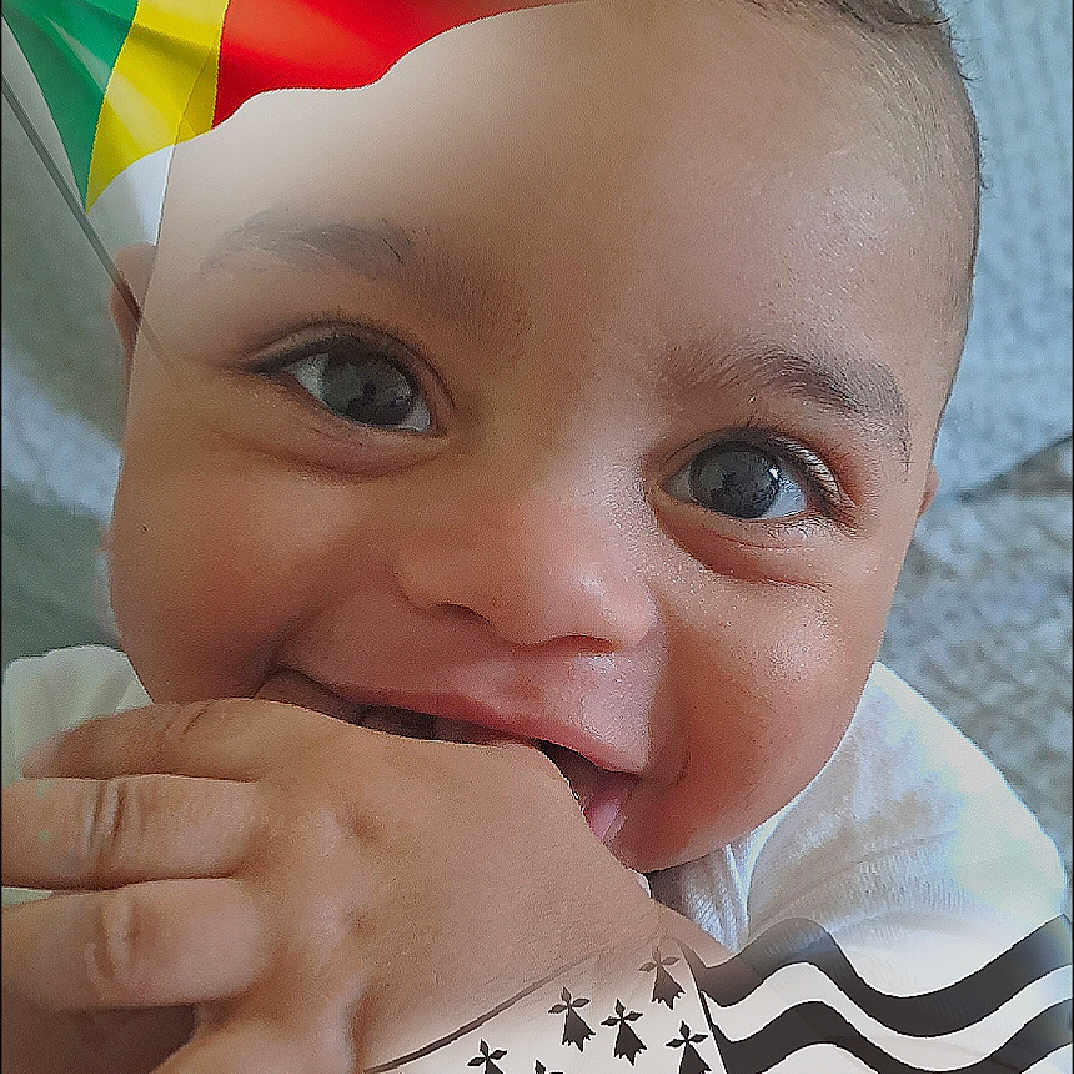 Maël participe au concours pour gagner de l'argent avec cette photo : baby, belgiumflag, bodypart, face, finger, flag, hand, head, person