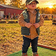 Sawyer is registered to the contest to win money with this photo: child, toddler, boy, portrait, outdoor, sunset, autumn, farm, playground, vest, jacket, cap, camouflage, jeans, sneakers, standing, smiling, sunlight, leaves, family_event