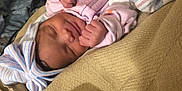 Armani is registered to the contest to win money with this photo: baby, blanket, child, clothing, comfort, cozy, cute, face, hand, hat, indoors, infant, newborn, peaceful, portrait, resting, sleeping, smile, soft, wrapped