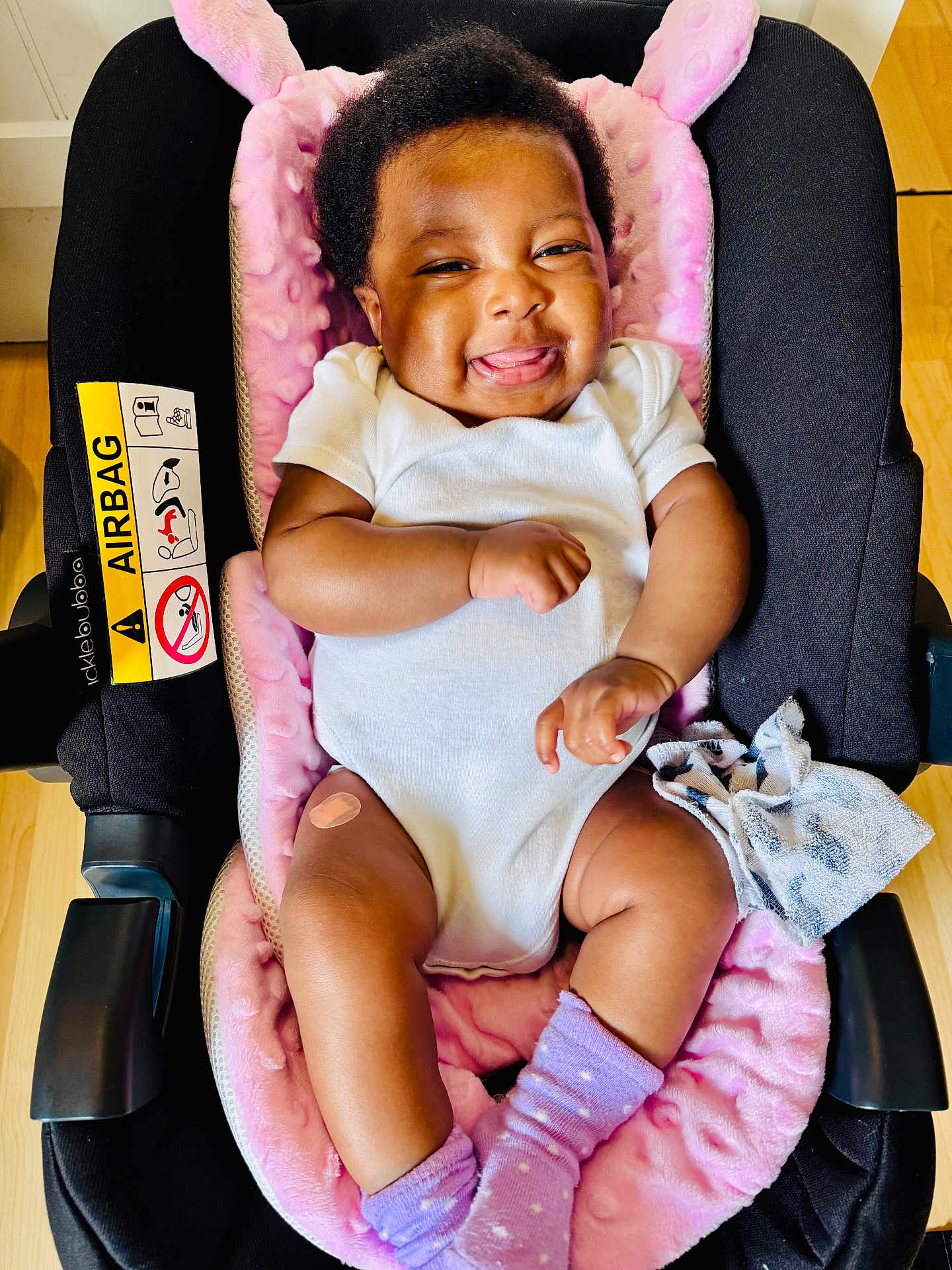 Bethel joined the competition — help win amazing prizes! baby, car_seat, infant, smile, white_onesie, purple_socks, bandage, pink_blanket, happy, tongue_out, indoor, wooden_floor, cloth, cute, child, person, seat, comfort, closeup, adorable