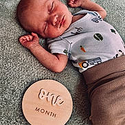 Emrys joined the competition — help win amazing prizes! baby, infant, sleeping, onesie, brown_pants, blanket, wooden_plaque, milestone, cute, newborn, peaceful, face, hand, soft_texture, sleep, lying_down, closeup, portrait, skin, child