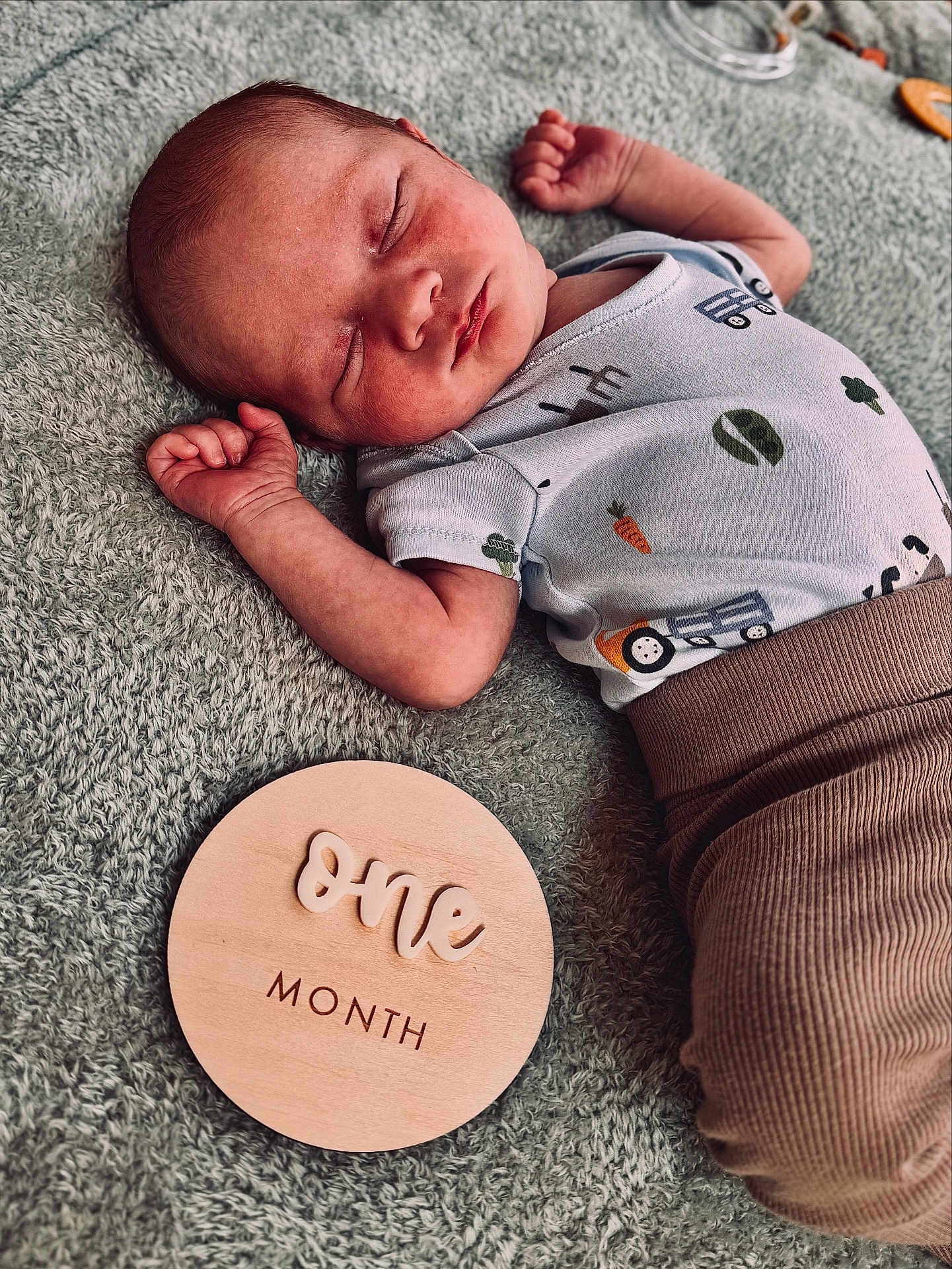 Emrys joined the competition — help win amazing prizes! baby, infant, sleeping, onesie, brown_pants, blanket, wooden_plaque, milestone, cute, newborn, peaceful, face, hand, soft_texture, sleep, lying_down, closeup, portrait, skin, child