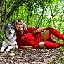 woman, dog, forest, red_clothing, cape, boots, greenery, leaves, path, nature, costume, smiling, posing, outdoor, animal, canine, adult, blonde_hair, red_lipstick, friendship