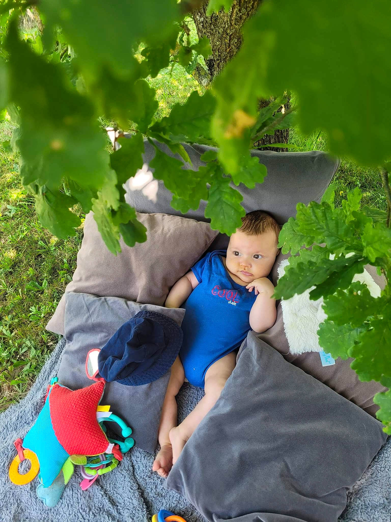 Léo a rejoint le concours — aidez-le/la à gagner de superbes lots ! baby, baby_products, child, electric_blue, fictional_character, fun, garden, grass, green, happy, human_body, leaf, leisure, people_in_nature, person, plant, recreation, sitting, t_shirt, toddler