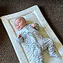 Ethan joined the competition — help win amazing prizes! baby, infant, onesie, lion_print, changing_pad, carpet, couch, floor, indoor, child, cute, lying_down, soft_furniture, small_person, portrait, clothing, resting, baby_garment, home_interior, relaxed