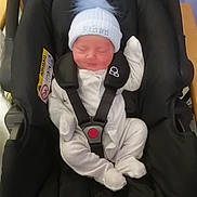 Ethan joined the competition — help win amazing prizes! baby, car_seat, infant, sleeping, white_clothing, hat, pom_pom, black_car_seat, safety_harness, indoor, newborn, cute, peaceful, soft, child, seatbelt, resting, small, adorable, cozy