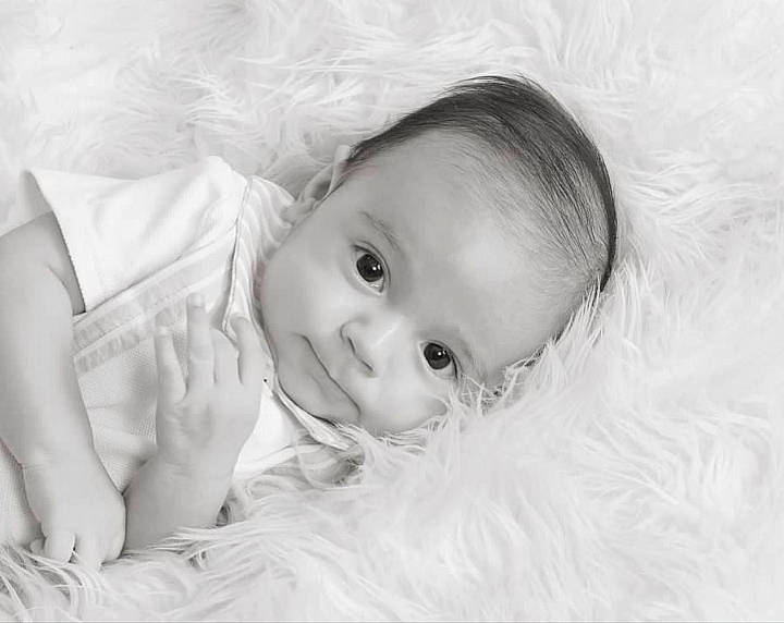 Sergio is registered to the contest to win money with this photo: baby, cheek, child, comfort, eye, eyebrow, face, flash_photography, grass, happy, head, human_body, iris, monochrome, monochrome_photography, nose, person, skin, smile, textile