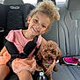 Ruby Sticker is registered to the contest to win money with this photo: girl, child, smiling, curly_hair, pink_dress, tutu, car_seat, backseat, car_interior, dog, poodle, small_dog, puppy, harness, seatbelt, cupholder, water_bottle, shoe, happy, portrait