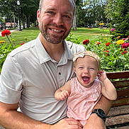 Lucy joined the competition — help win amazing prizes! man, baby, child, smiling, outdoor, park, bench, flowers, nature, greenery, happy, family, portrait, casual_clothing, headband, sunlight, daytime, person, grass, tree