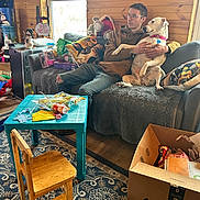 Diamond joined the competition — help win amazing prizes! man, dog, couch, wood_wall, window, christmas_decorations, pillow, table, chair, carpet, cardboard_box, gift_wrap, glasses, hoodie, indoor, relaxed, holiday, living_room, home, casual