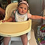 baby, high_chair, bib, pink_headband, child, indoor, curious, rosy_cheeks, tableware, china_cabinet, blanket, hello_kitty, tile_floor, person, cute, infant, furniture, reaching_out, pink_clothing, foot