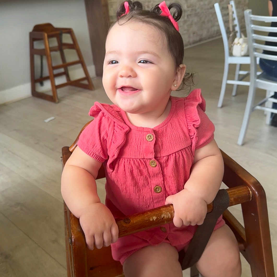 Manuela joined the competition — help win amazing prizes! baby, brick_wall, cafe, casual, child, cute, hair_bows, happy, high_chair, holding, indoor, infant, person, pink_clothing, playful, portrait, sitting, smiling, wooden_bar, wooden_furniture