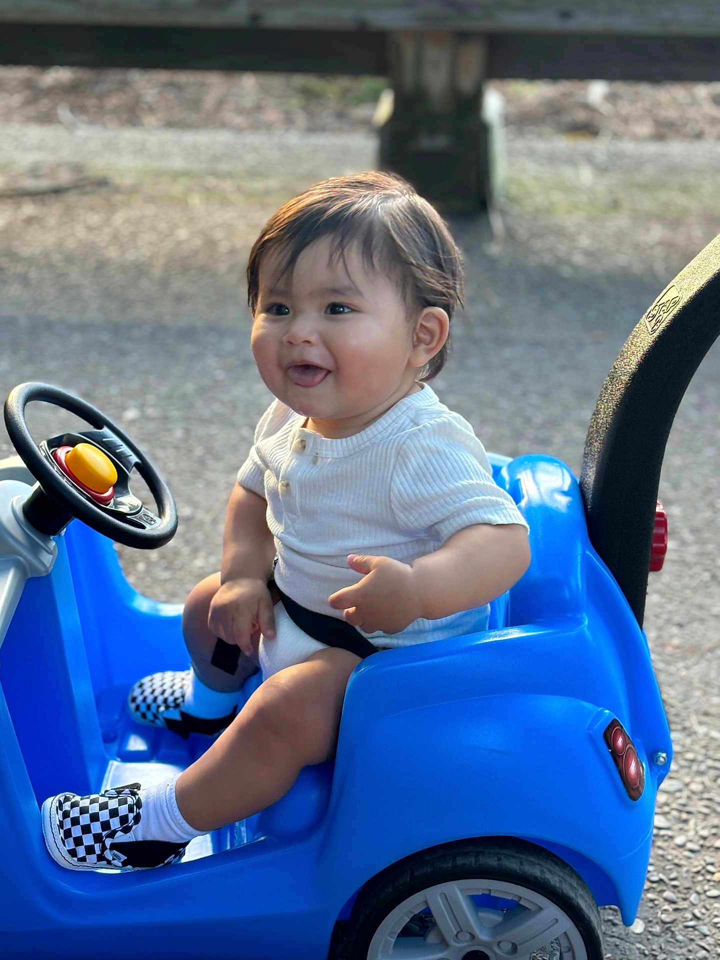 Darian joined the competition — help win amazing prizes! baby, child, toddler, toy_car, blue, smiling, sitting, outdoor, steering_wheel, white_shirt, checkered_shoes, happy, shorts, seat_belt, sunlight, playtime, small_vehicle, young_child, cute, casual_clothing