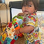 baby, carpet, child, colorful_clothing, curious, expression, face, footwear, furniture, hair, hand, home, indoor, person, play, room, sesame_street, standing, toddler, toy_walker