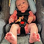 baby, car_seat, child, child_seat, cute, face, feet, foot, head_support, human, indoor, infant, looking, newborn, peach_outfit, safe, seat_belt, sitting, small, straps