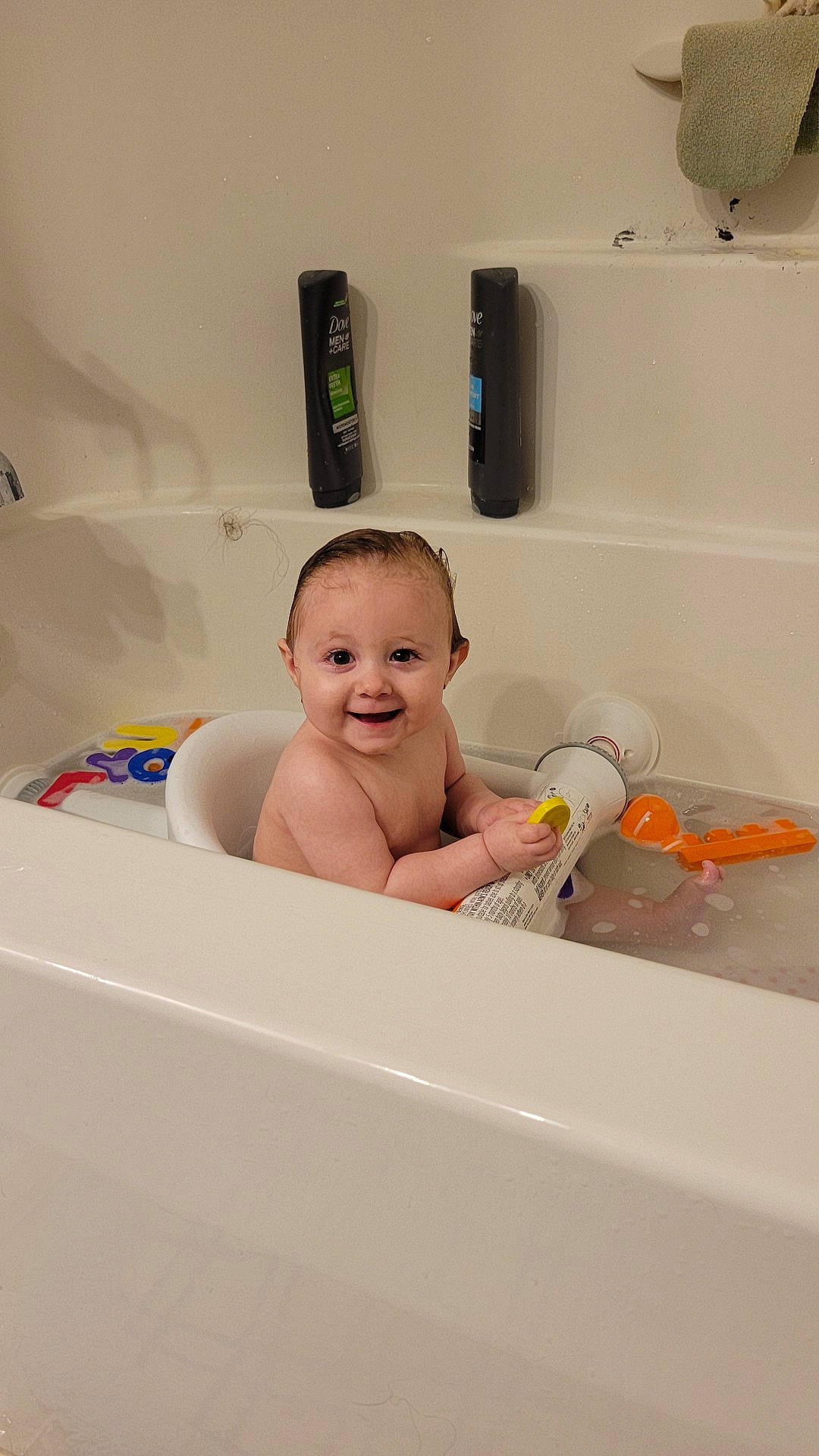 Rin is registered to the contest to win money with this photo: baby, bathing, bathroom, bathroom_accessory, bathtub, child, floor, flooring, fluid, happy, household_supply, joy, mechanical_fan, paper_towel, person, personal_care, plumbing, plumbing_fixture, room, smile
