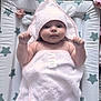 baby, infant, towel, hooded_towel, changing_mat, star_pattern, pacifier, pink, soft_texture, cute, child, newborn, lying_down, raised_fists, indoor, face, skin, expression, blanket, comfort
