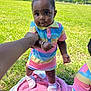 baby, child, outdoor, grass, pink_blanket, colorful_clothing, sneakers, holding_hand, tattoo, tree, sunny_day, person, portrait, cute, smiling, walking, park, playtime, summer, nature