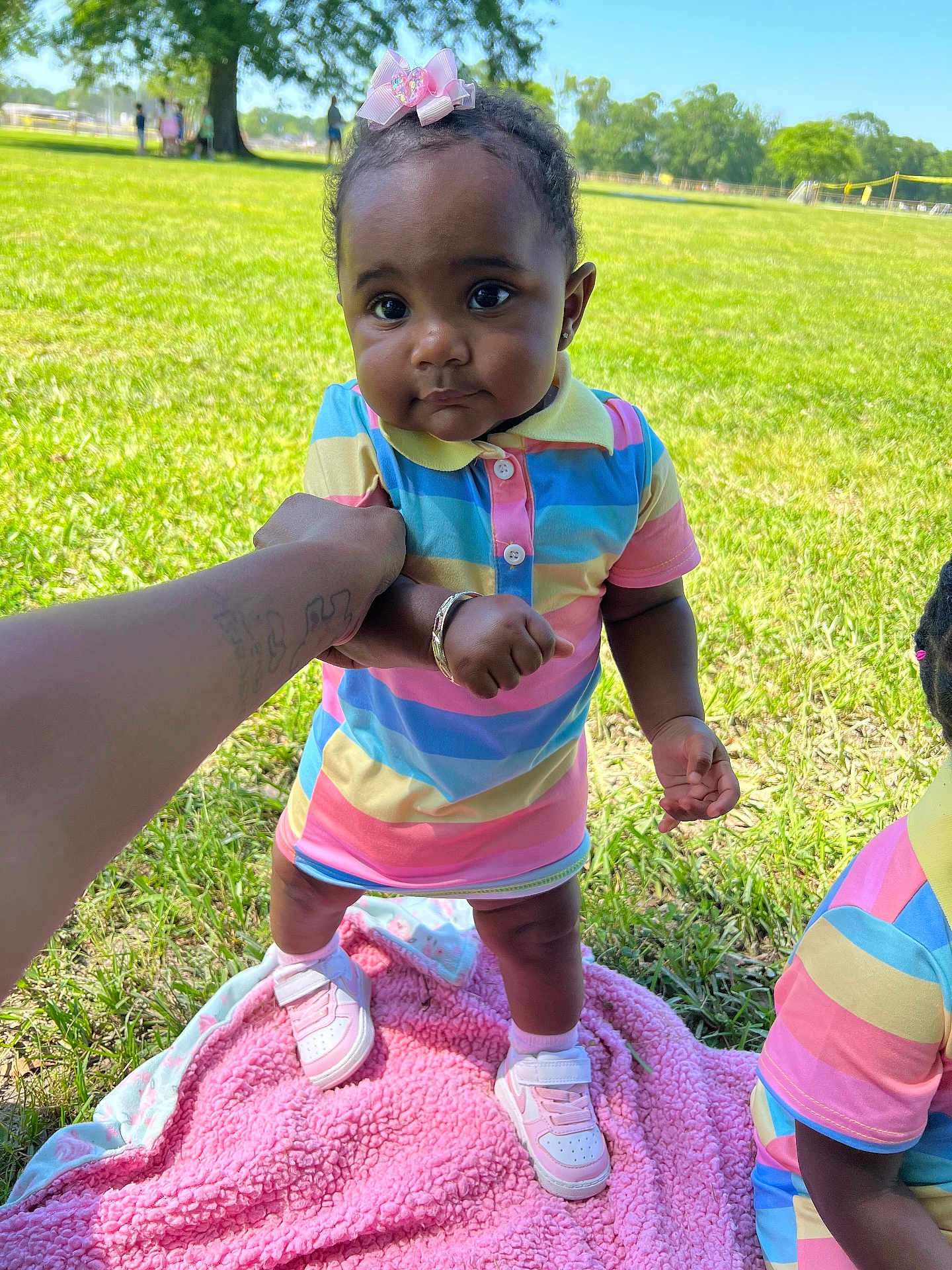 Kali joined the competition — help win amazing prizes! baby, child, outdoor, grass, pink_blanket, colorful_clothing, sneakers, holding_hand, tattoo, tree, sunny_day, person, portrait, cute, smiling, walking, park, playtime, summer, nature