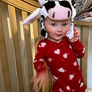 Delilah joined the competition — help win amazing prizes! child, baby, onesie, red_clothing, heart_pattern, cow_hat, crib, blanket, bedroom, indoor, person, motion_blur, cute, playful, headwear, infant, toddler, furniture, soft_toys, sleepwear