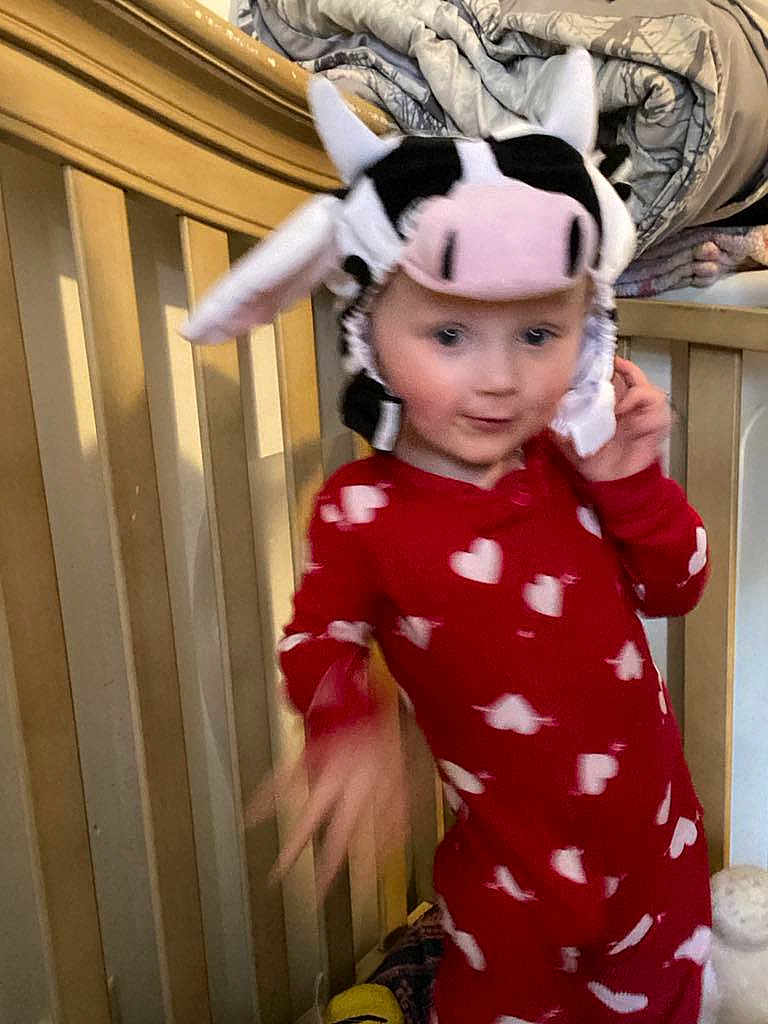 Delilah joined the competition — help win amazing prizes! child, baby, onesie, red_clothing, heart_pattern, cow_hat, crib, blanket, bedroom, indoor, person, motion_blur, cute, playful, headwear, infant, toddler, furniture, soft_toys, sleepwear