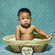 Sakani Lay is registered to the contest to win money with this photo: baby, nine_months, drool, basket, infant, portrait, cute, child, milestone, skin, hand, curly_hair, expression, background, texture, sitting, indoors, fabric, photo_shoot, milestone_sign