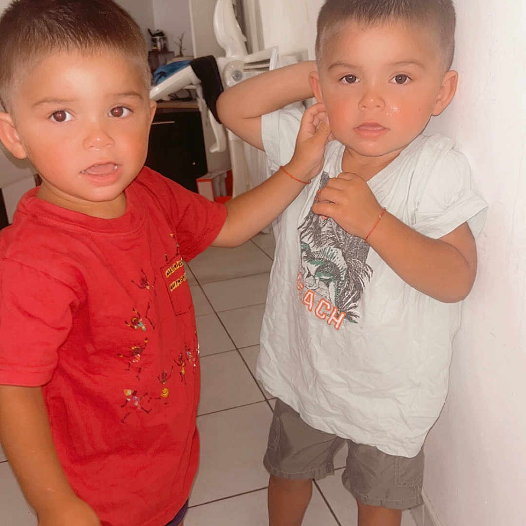 Kayden Aaron participe au concours pour gagner de l'argent avec cette photo : barefoot, boy, cabinet, casual_clothing, child, floor, furniture, home, indoor, kitchen, person, red_shirt, shorts, siblings, slippers, standing, tile, tiled_floor, wall, white_shirt