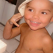 Kayden Aaron a rejoint le concours — aidez-le/la à gagner de superbes lots ! baby_teeth, bare_chest, cabinet, child, cute, expression, face, hand, happy, hat, headwear, home, indoor, person, playful, skin, smiling, tile_floor, toddler, young_child