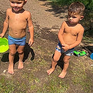 Kayden Aaron a rejoint le concours — aidez-le/la à gagner de superbes lots ! child, boy, barefoot, swim_trunks, outdoor, grass, mud, sunlight, smiling, serious, toy_car, man, walking, stone_wall, path, summer, nature, daylight, play, green_bowl