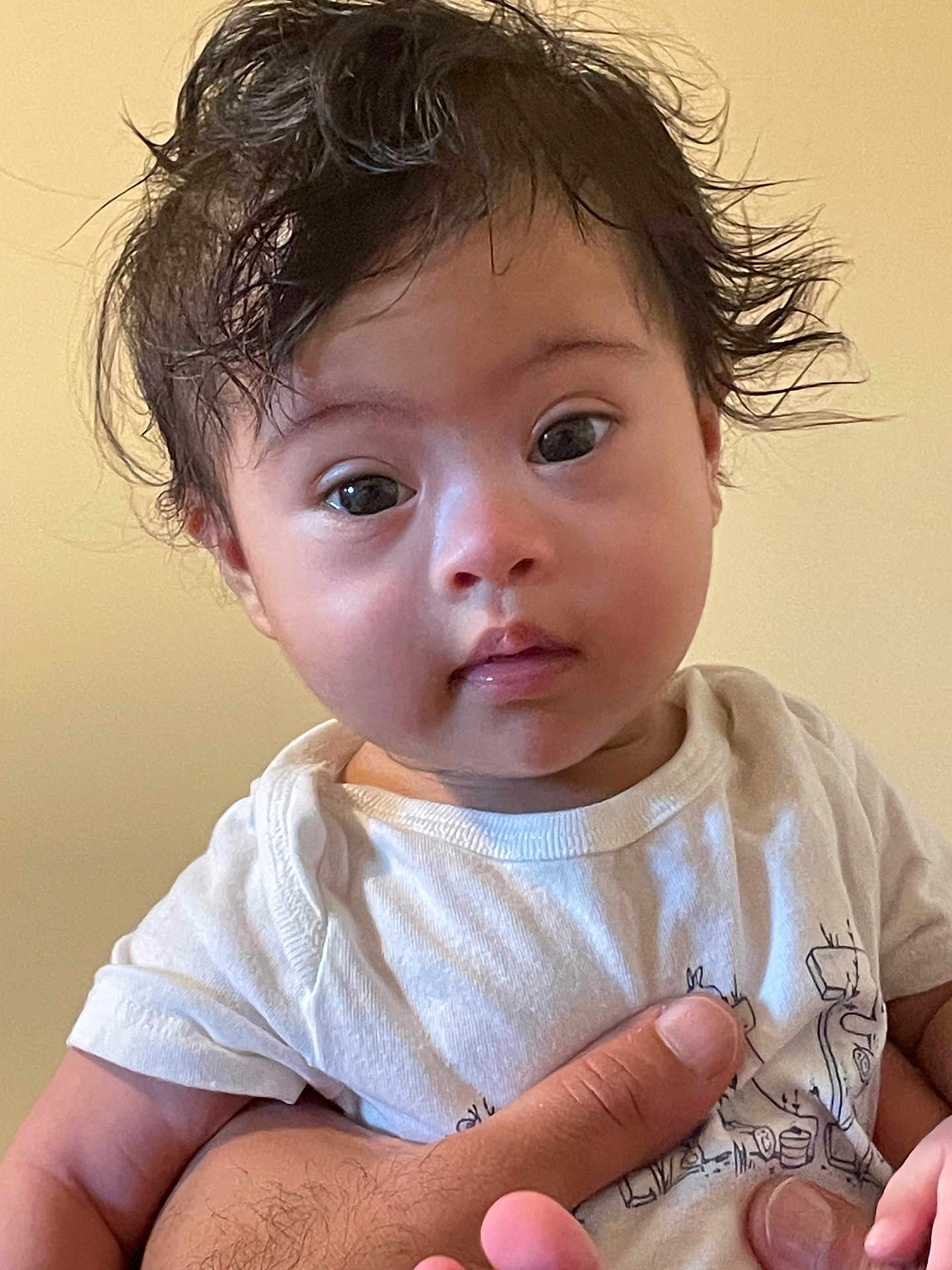 Ayan Raheem is registered to the contest to win money with this photo: baby, child, infant, face, hair, hand, white_shirt, curious_expression, portrait, human, skin, eyes, cute, indoor, person, young_child, holding, toddler, casual_clothing, neutral_background