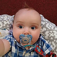 Nekoda joined the competition — help win amazing prizes! baby, child, pacifier, blue_eyes, checkered_shirt, close_up, selfie, infant, cute, face, pacifier_clip, patterned_cushion, red_carpet, indoor, plush, wide_eyes, clothing, person, portrait, curious