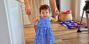 Raea is registered to the contest to win money with this photo: toddler, child, dress, indoor, walking, person, hand_holding, floor, wooden_floor, home, basket, clothing, barefoot, adult, support, face, hair, room, door, furniture