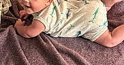 Shawn is registered to the contest to win money with this photo: baby, child, infant, smiling, portrait, lying_down, blanket, purple_blanket, dinosaur_outfit, onesie, clothing, face, eyes, hands, legs, indoor, cozy, happy, candid, photography