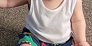 Ollie joined the competition — help win amazing prizes! baby, barefoot, bracelet, carpet, casual_clothing, child, colorful_shorts, cute, dinosaur_print, fun, happy, indoor, person, playful, portrait, sitting, smile, toddler, white_shirt, young_child