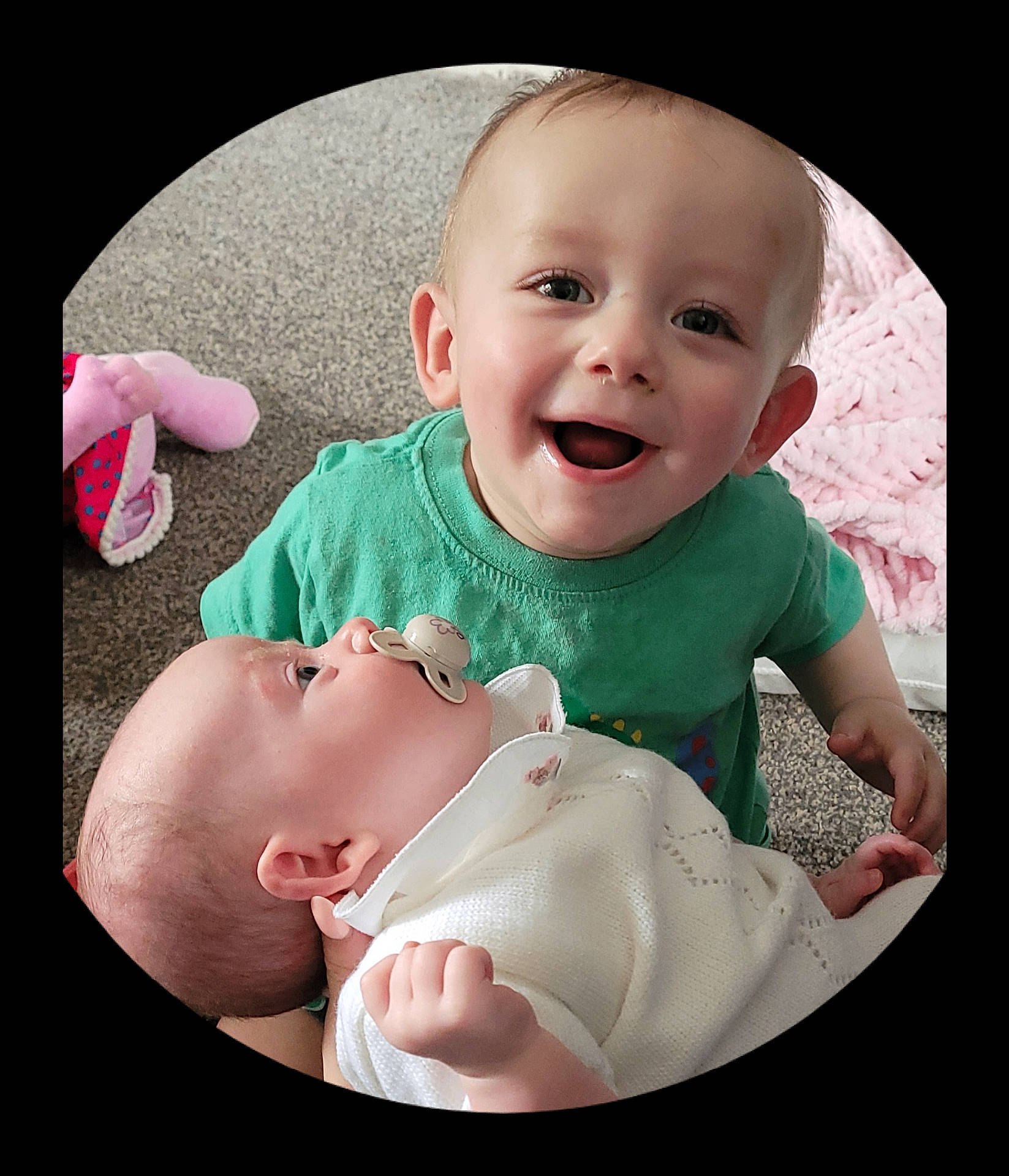 baby, blanket, carpet, child, cozy, cute, face, family, green_shirt, happy, head, holding, indoor, infant, pacifier, person, play, smile, toddler, white_clothing
