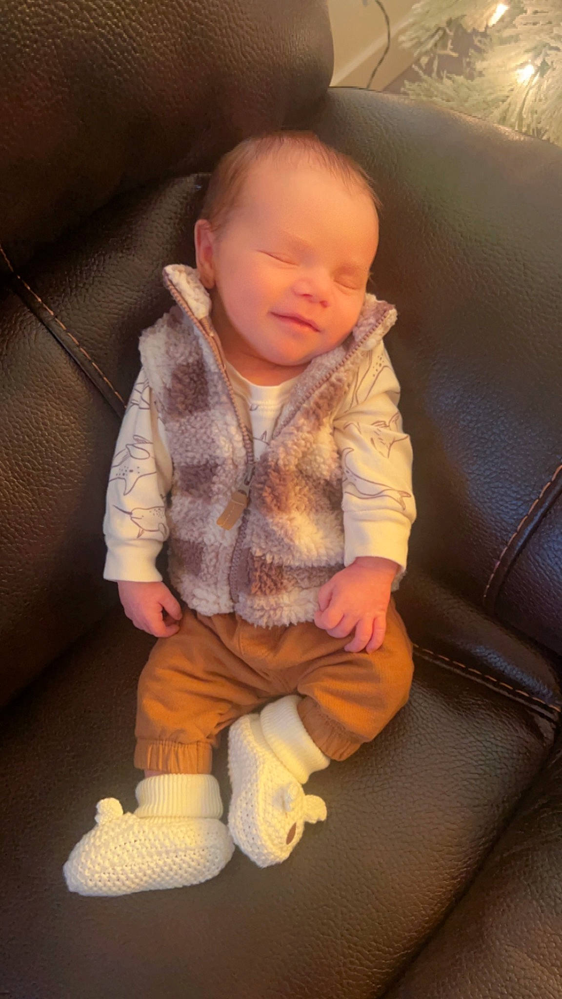 Axton is registered to the contest to win money with this photo: arm, baby, baby_toddler_clothing, car_seat, cheek, comfort, couch, flooring, human_body, human_leg, knee, lap, leg, nose, person, skin, sleeve, sock, thigh, thumb