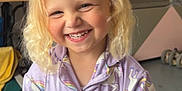 Méloa a rejoint le concours — aidez-le/la à gagner de superbes lots ! blonde_hair, casual, child, colorful, cozy, curly_hair, cute, face, fun, happy, indoor, onesie, pajamas, person, playful, portrait, smiling, toy, unicorn_pattern, young_child