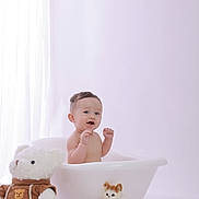 Maximillian joined the competition — help win amazing prizes! baby, child, infant, bathtub, teddy_bear, stuffed_animal, plush_kitten, portrait, indoors, nursery, pastel, white_background, soft_lighting, sitting, smiling, surprised, raised_hands, toy, cute, photography