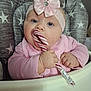 baby, child, candy_cane, pink_clothing, headband, bow, high_chair, star_pattern, indoor, cute, chubby_cheeks, hand, face, blue_eyes, infant, pacifier, holiday, sweet, portrait, young_child