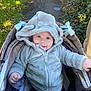 baby, infant, hoodie, stroller, outdoor, happy, smile, face, clothing, cute, child, nature, greenery, path, babywear, cold_weather, joyful, cute_expression, person, infant_clothing