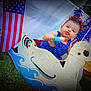 Victoria is registered to the contest to win money with this photo: toddler, child, denim_overalls, wooden_duck, rocker, grass, american_flag, popsicle, patriotic, headband, red_white_blue, outdoor, summer, celebration, holiday, toy, playful, smiling, face, festive