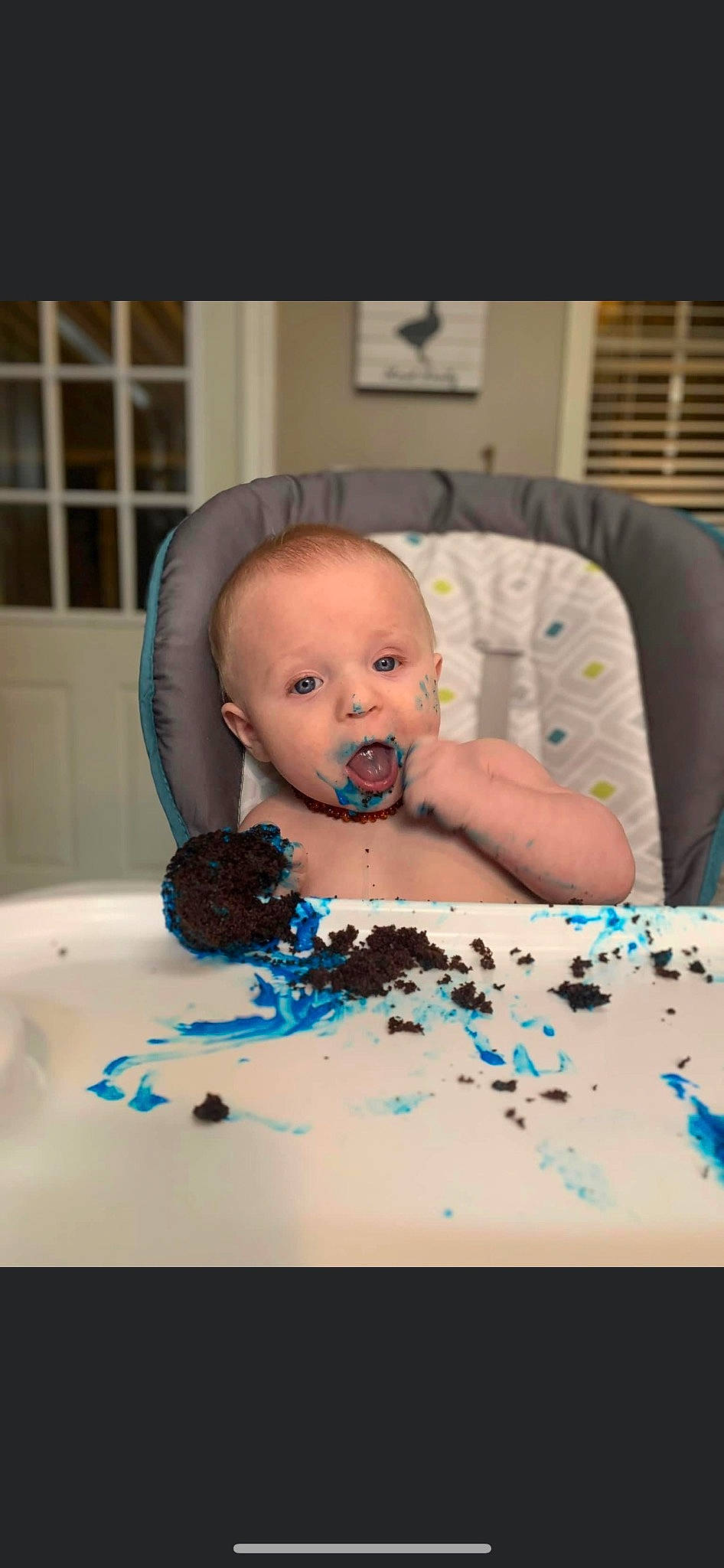 Easton is registered to the contest to win money with this photo: baby, baby_toddler_clothing, cake, cake_decorating, cheek, child, comfort, dessert, flooring, food, fun, hairstyle, icing, iris, linens, person, play, room, sitting, surprise