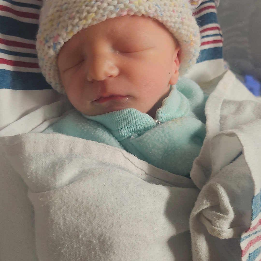 Huxlen is registered to the contest to win money with this photo: baby, blanket, child, closeup, clothing, cozy, cute, hat, human, indoors, infant, newborn, peaceful, portrait, resting, sleeping, soft, swaddled, tiny, wearing